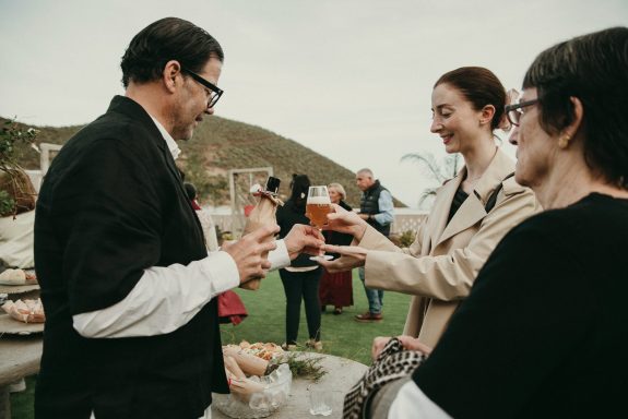 Atención personalizada en organización de eventos Grupo de personas brindando con copas en un evento al aire libre.