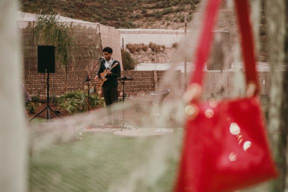 Música en directo en eventos personalizados Primer plano un bolso rojo expuesto desenfocado, segundo plano cantante actuando en directo en evento