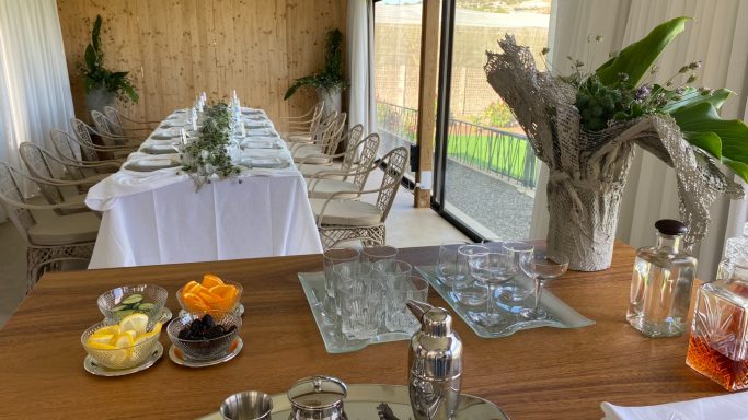 Eventos privados, celebración Mesa decorada con mantelería blanca y flores, en un ambiente luminoso y natural.