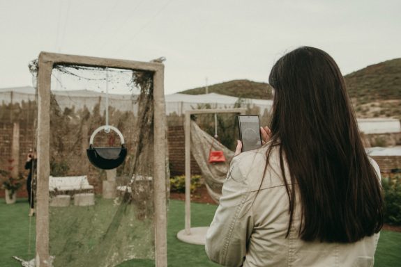Presentación nueva colección bolsos de diseño Una mujer fotografiando un bolso azul marino expuesto en decorado